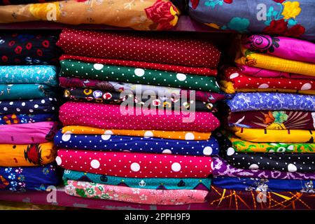 Artistic variety shade tone colors Textile Fabrics stacked on retail Shop Shelf to sale Stock Photo