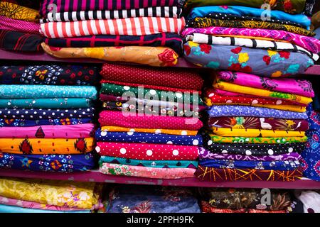 Artistic variety shade tone colors Textile Fabrics stacked on retail Shop Shelf to sale Stock Photo