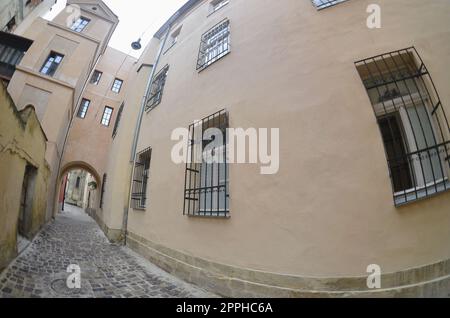 Narrow street with a path of paving stones. Passage between the old historical high-rise buildings in Lviv, Ukraine Stock Photo