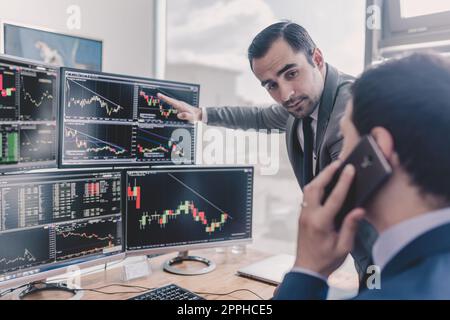 Stock brokers looking at computer screens, trading online. Stock Photo