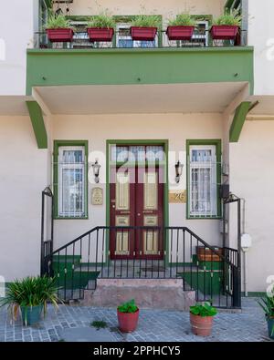 Old colorful wooden residential building with door, wrought iron windows and green climber plants, Istanbul, Turkey Stock Photo