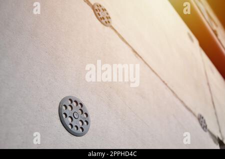 The texture of the wall, covered with gray foam polystyrene plates, which are reinforced with plastic umbrella dowels. Stage of wall insulation Stock Photo