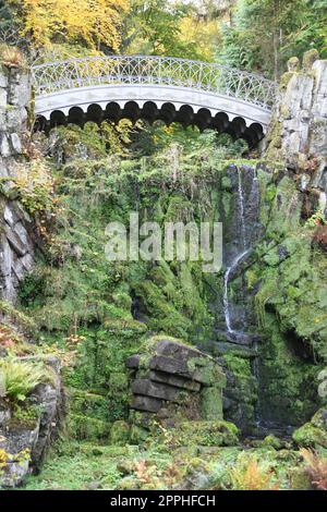 The devils bridge in the Bergpark WilhelmshÃ¶he in the city of Kassel in Hesse spans the HÃ¶llenteich. In 1826 the lattices of the bridge were cast from solid metal. A popular destination Stock Photo