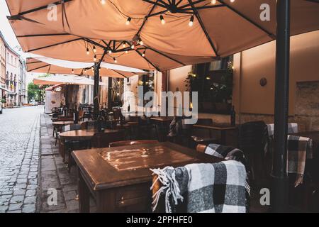 Spend time on terrace: cozy street cafe interior with wooden wicker chairs and blooming hydrangea. Garden or dacha restaurant outside city. Stylish patio at hotel or spa. Design and decoration concept Stock Photo