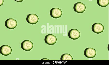 Trendy pattern made with sliced cucumbers on light green background. Minimal trendy food and freshness concept. Stock Photo