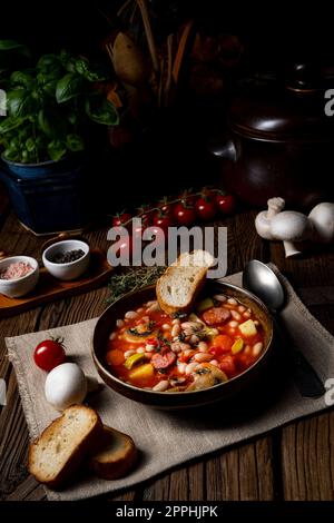 rustic bean soup with potatoes and sausages Stock Photo