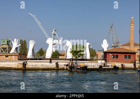 Giant joined hands sculpture Building Bridges by Lorenzo Quinn. Exhibition at Arsenale, Castello, Venice Stock Photo