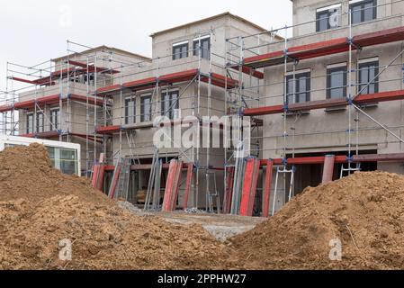 Scaffolded shells of single-family houses under construction Stock Photo