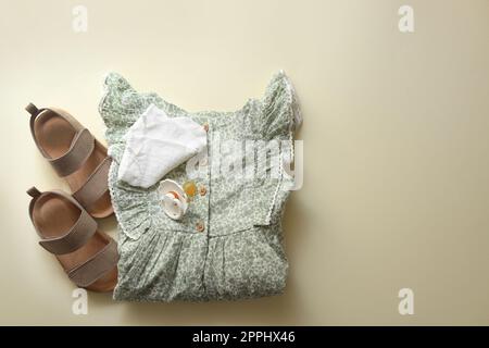 Stylish child clothes, shoes and pacifier on beige background, flat lay. Space for text Stock Photo