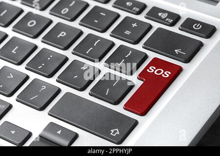 Red button with word SOS on computer keyboard, closeup. Rescue concept Stock Photo