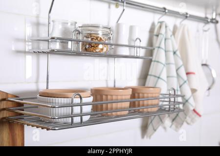 Many different ramekins on metal rack in kitchen Stock Photo