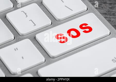Button with word SOS on computer keyboard, closeup. Rescue concept Stock Photo