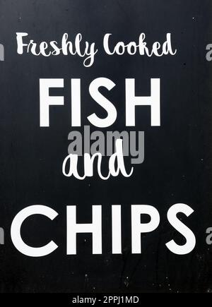 Freshly cooked Fish and Ships writing against a black background, Sidmouth, Devon, UK, Europe Stock Photo
