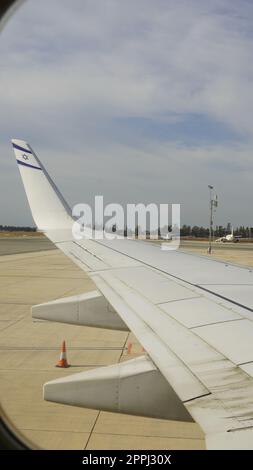 Wing of an airplane, passenger s view. Looking through the window of a plane wile it's in airport Stock Photo