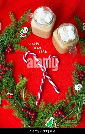 Closeup of marshmellou cocoa and candy on a red background. The inscription Happy New Year Stock Photo