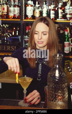 Bartender-girl mixing cocktail behind the counter Stock Photo