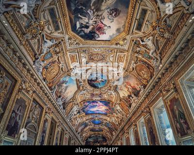 The Galerie d'Apollon a large and iconic room of the Louvre museum. Apollon gallery is a gold decorated hall with zodiac signs ornaments and murals on the walls and ceiling. Architectural masterpiece Stock Photo
