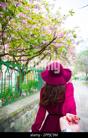 Woman in red dress holding hand of man Stock Photo