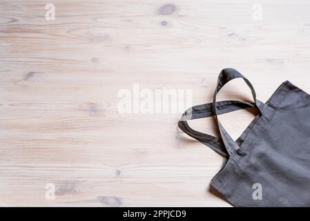 Gray fabric cotton bag on light wooden background, copy space. Eco friendly and zero waste lifestyle concept. Stock Photo