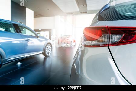 Rearview car parked in luxury showroom. Car dealership office. New car parked in modern showroom. Car for sale and rent business concept. Automobile leasing and insurance concept. Electric automobile. Stock Photo