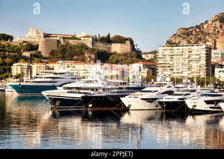 Monte Carlo, Monaco - Port Hercule with luxury yachts,  boats, and scenery skyline Stock Photo