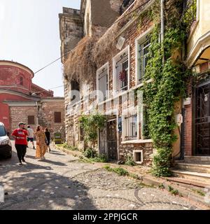 Cobblestone alley with beautiful old traditional red bricks houses in Balat district, on a summer day, Istanbul, Turkey Stock Photo