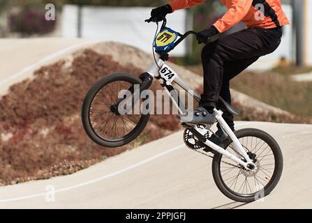 Young boy jumping with his BMX bike at pump track. BMX racing track. Cyclist riding on pump track. Rider in action at bike sport Stock Photo