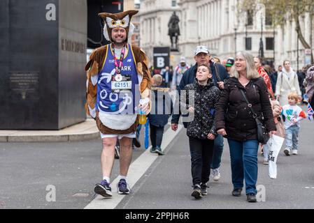 Mark Standing in owl costume after the London Marathon 2023 race. With medal and family or friends Stock Photo