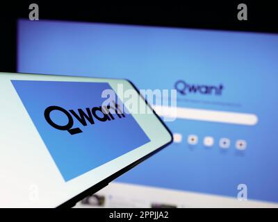 Mobile phone with logo of French search engine company Qwant SAS on screen in front of business website. Focus on center-left of phone display. Stock Photo