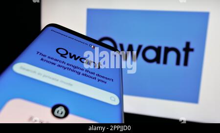 Smartphone with webpage of French search engine company Qwant SAS on screen in front of business logo. Focus on top-left of phone display. Stock Photo