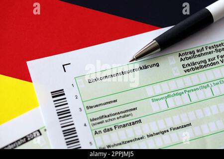 German annual income tax return declaration form with pen on flag close up. The concept of tax reporting in Germany Stock Photo