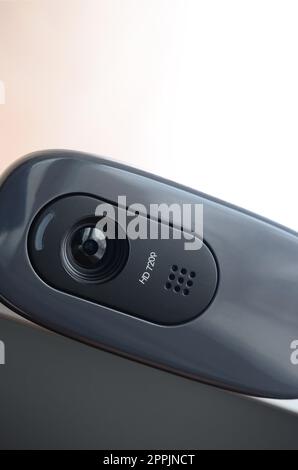 A modern web camera is installed on the body of a flat screen monitor ...