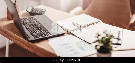 Close-up panoramic view of the table with laptop and papers on it in the office Stock Photo