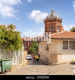 Cobblestone alley in old Balat district, with Phanar Greek Orthodox College, or Ozel Fener Rum Lisesi, Istanbul, Turkey Stock Photo