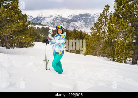 Portrait of a woman standing in deep snow and holding ski, Andorra, Pyrenees Stock Photo