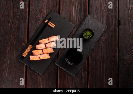 Sushi roll philadelphia with crab and cucumber and cream cheese, caviar on black background top view. Sushi menu. Japanese food concept Stock Photo
