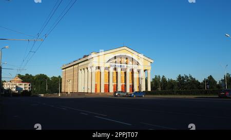 The Musical Theater of the Republic of Karelia is a state theater in Petrozavodsk. People are walking. Cars drive along Kirov Square. A car is passing along Karl Marx Street. Blue sky. August 3, 2022 Stock Photo