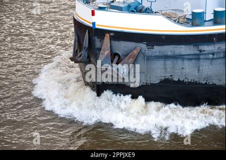 Detail of bow wave and bow with thinned anchors of a barge in full sail on a river Stock Photo