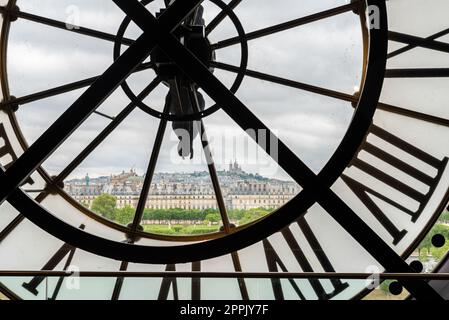 View of church Sacre Coeur in Montmartre through a large Clock from Museum d'Orsay in Paris Stock Photo