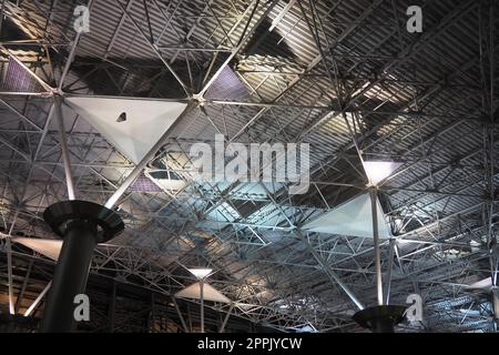 Metal structures under the ceiling. Decorative details of the airport ceiling . Concrete beams, glass windows and metal elements as public building interior design. Abstract avant-garde architecture. Stock Photo