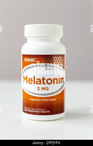 Kyiv, Ukraine - 27 January 2022: Jar of Melatonin capsules from GNC. 3 mg tablet to improve sleep and fight insomnia - nutritional supplement and medicine for men and women. Shallow depth of field. Stock Photo