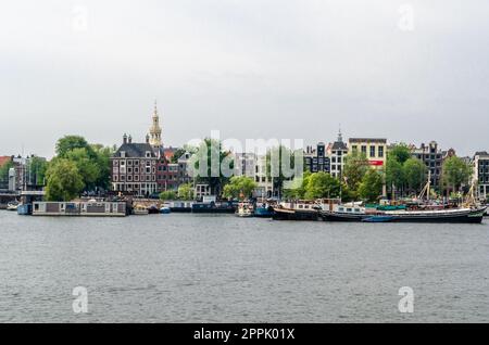 AMSTERDAM, THE NETHERLANDS - AUGUST 24, 2013: View of Amsterdam with the river and boats, in the area of the central train station Stock Photo