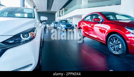 White car parked in luxury showroom. Car dealership office. New car parked in modern showroom. Car for sale and rent business concept. Automobile leasing and insurance concept. Electric vehicle. Stock Photo