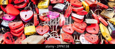 Verona, Italy - June 2022: background of heart-shaped locks on a wall, symbol of love forever. Stock Photo