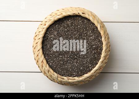 Wicker box with chia seeds on white wooden table, top view Stock Photo