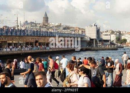 Eminonu Square overlooking Galata Bridge, Galata Tower, and crowds of People during Victory Day, Istanbul, Turkey Stock Photo