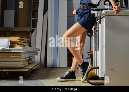 Female legs near a woodworking machine Stock Photo