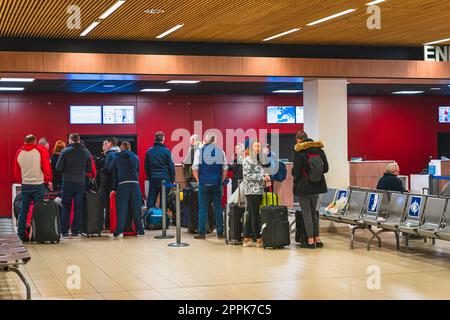 People standing with luggage in a queue for check in and flight departure, Perpignan airport Stock Photo