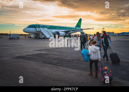 People going to airplane parked on runway at Perpignan airport Stock Photo