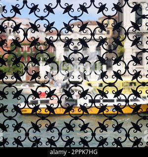 Detail of an ancient window with grating in wrought iron. Venice Stock Photo